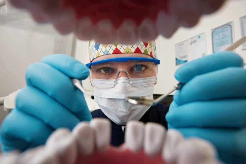 dentista haciendo checkeo boca paciente