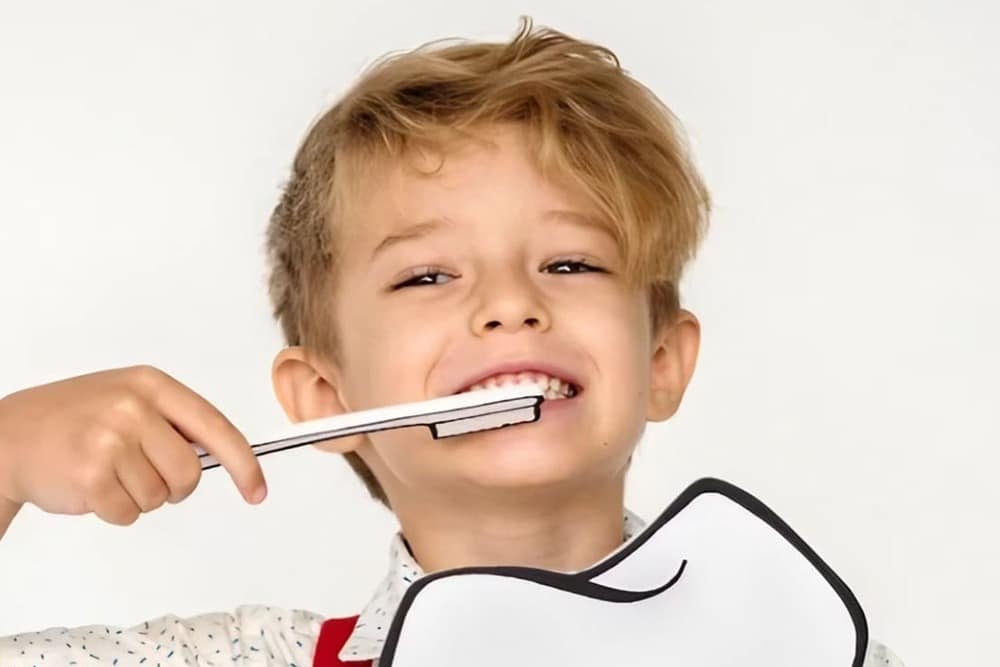 niño posando con cepillo de dientes