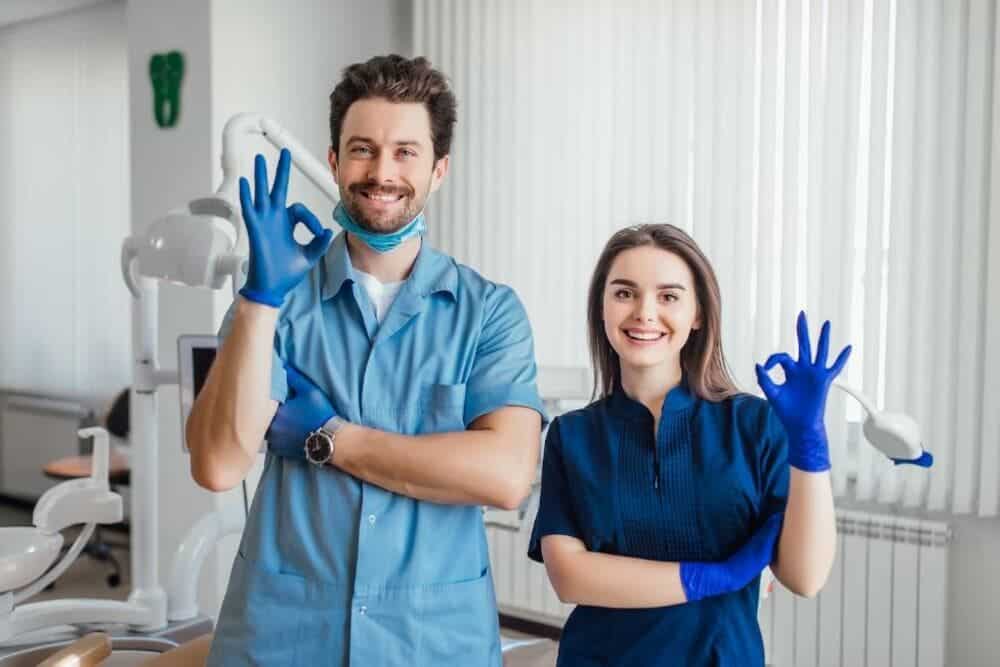 dentistas jóvenes simpáticos posando en clínica