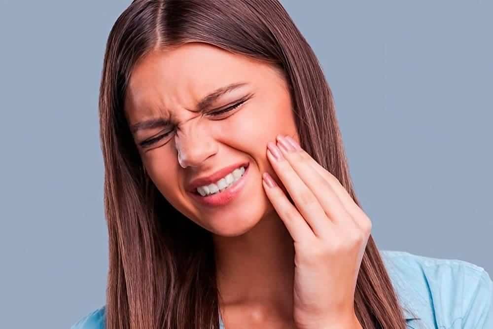 mujer joven con dolor dental