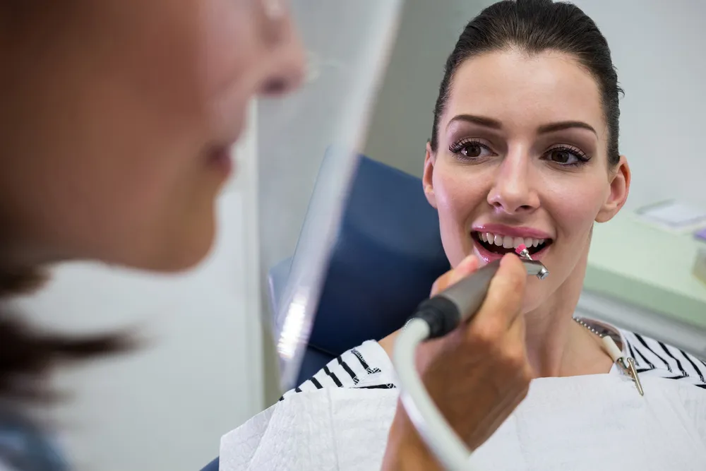 mujer joven teniendo chequeo dental